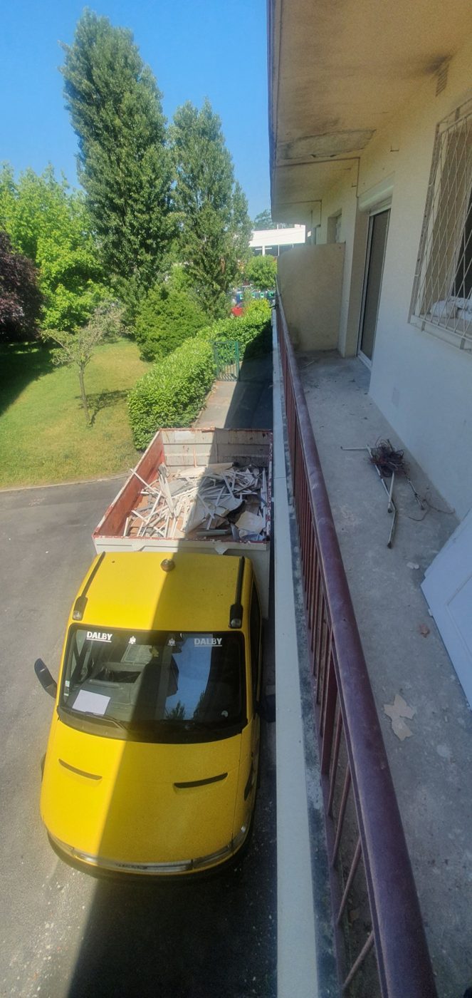 Benne de location posée le long d'un immeuble pendant des travaux