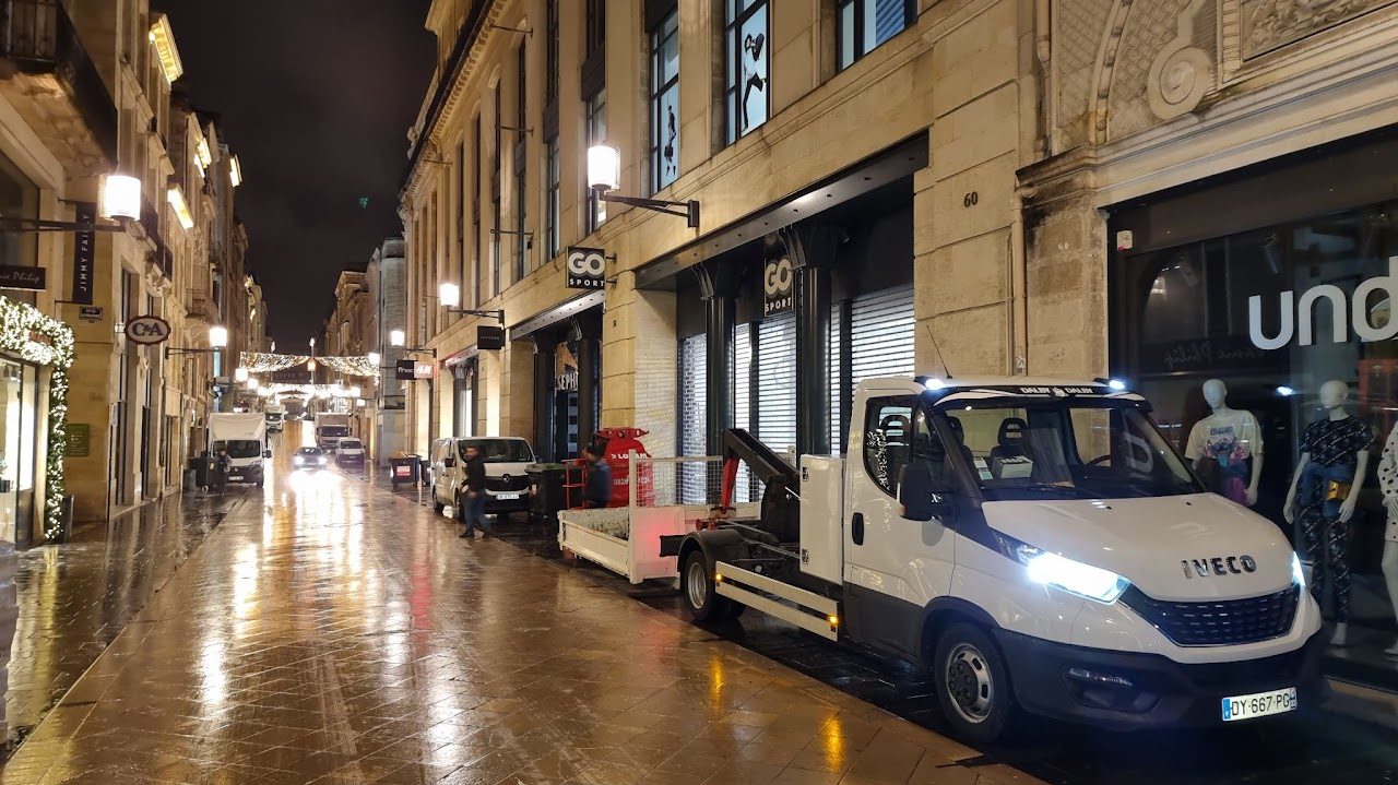 Camion benne de nuit dans une rue commerçante du centre-ville de Bordeaux