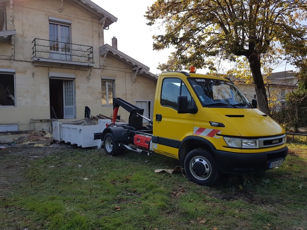 Dépôt d'une benne de location sur un chantier en Gironde